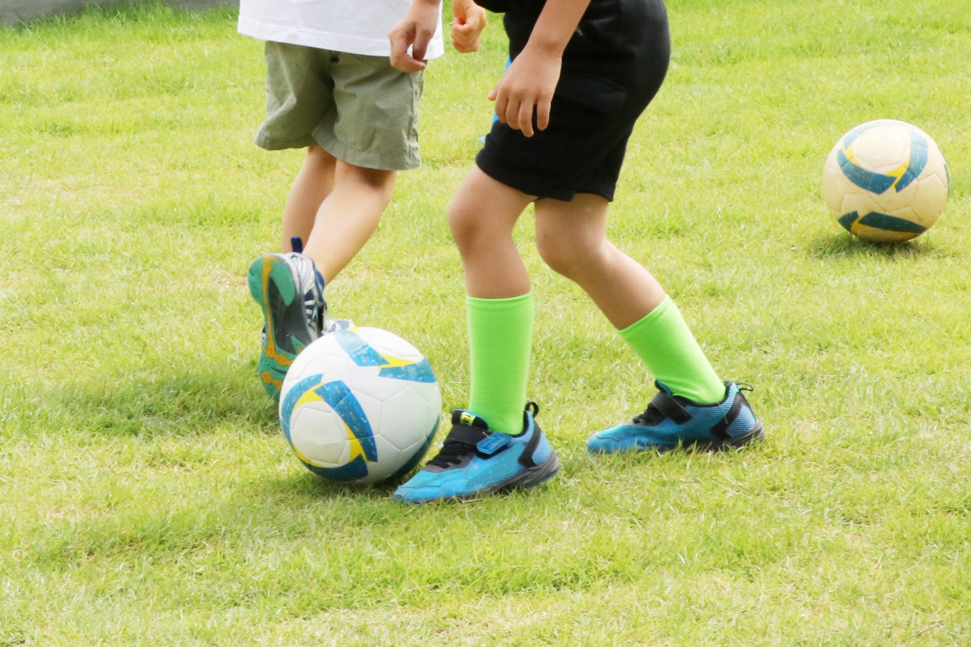 サッカーをしている２人の子どもの足元
